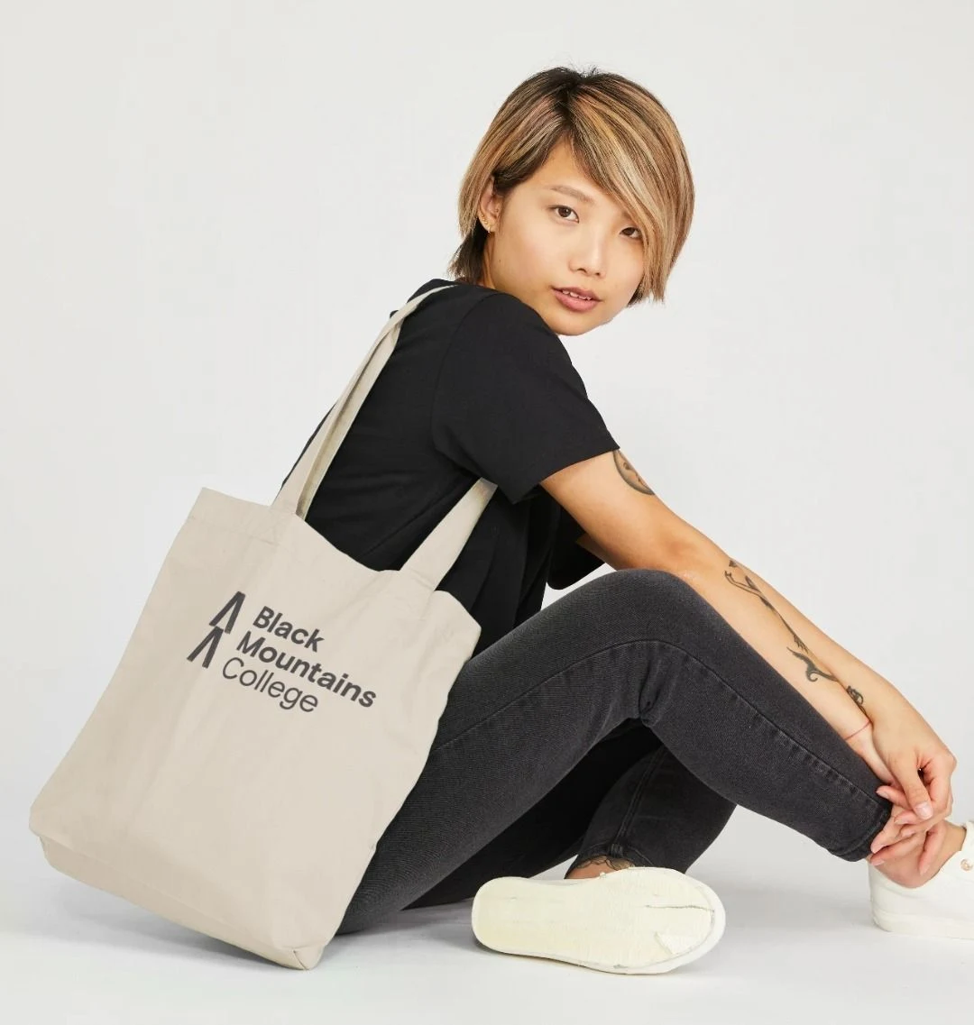 A woman with a Black Mountains College tote bag